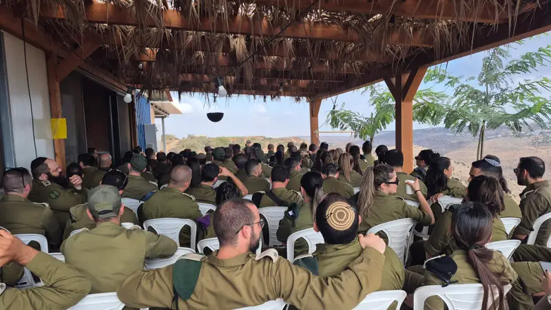 קבוצת חיילים בשיחה מתחת לפרגולה של החווה